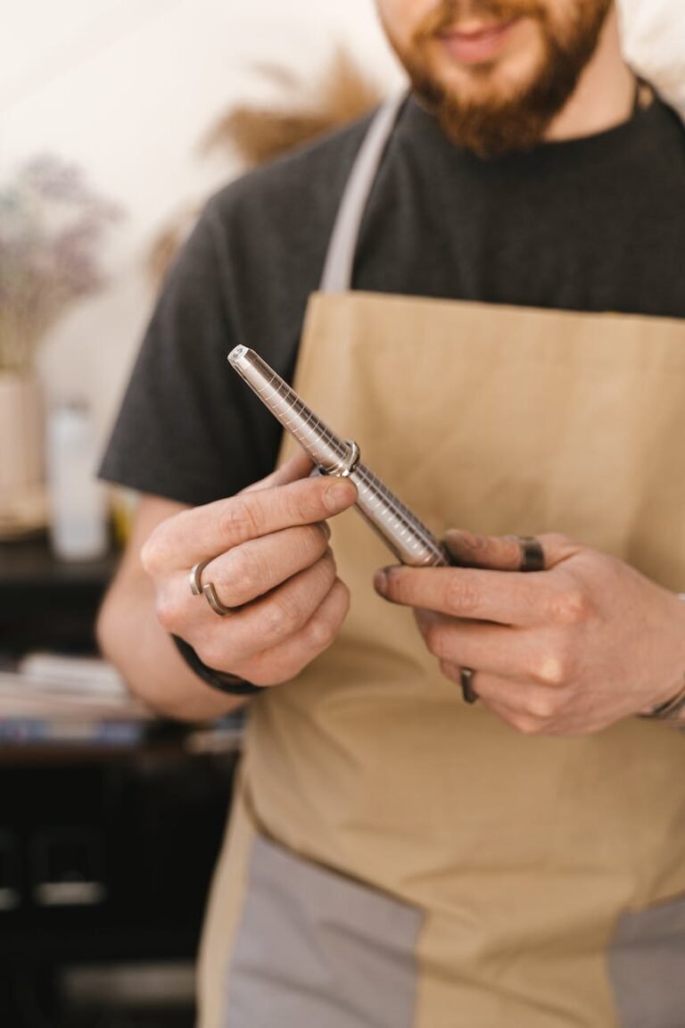 close up of a jeweller wearing a beige apron measuring ring size